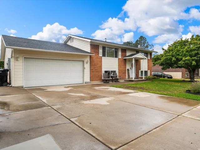 Two-story residence featuring brick and siding facade, covered front entry, attached garage, and paved driveway