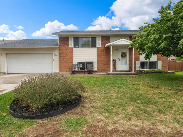 Brick and siding exterior with an attached garage, covered entry, and front yard landscaping