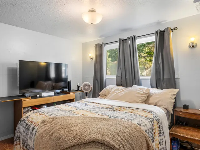Recessed window with exterior scenery, wall-mounted sconce lighting, and wood-finish flooring