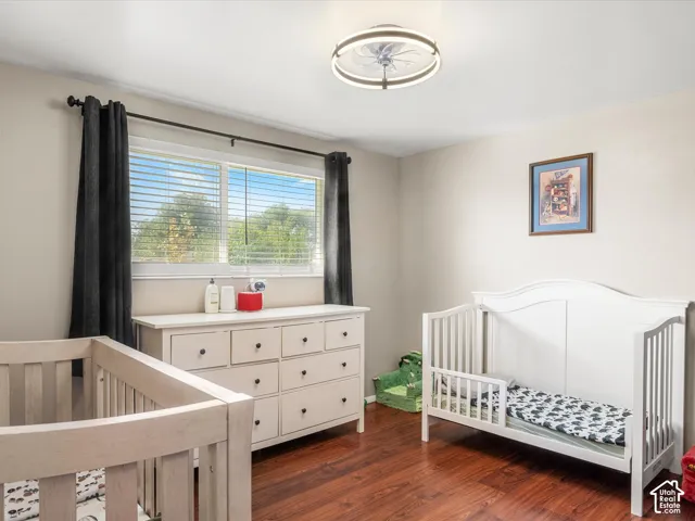 Hardwood-finish flooring, recessed lighting, and a window with blinds and dark-hued curtains