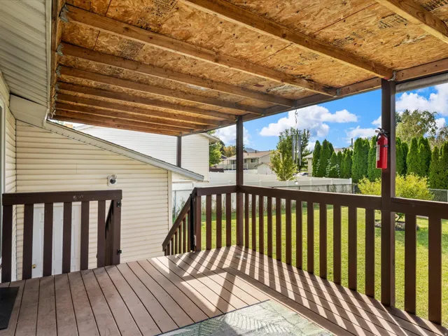 Covered deck featuring composite decking, wood railing, and an exposed wood-finish ceiling