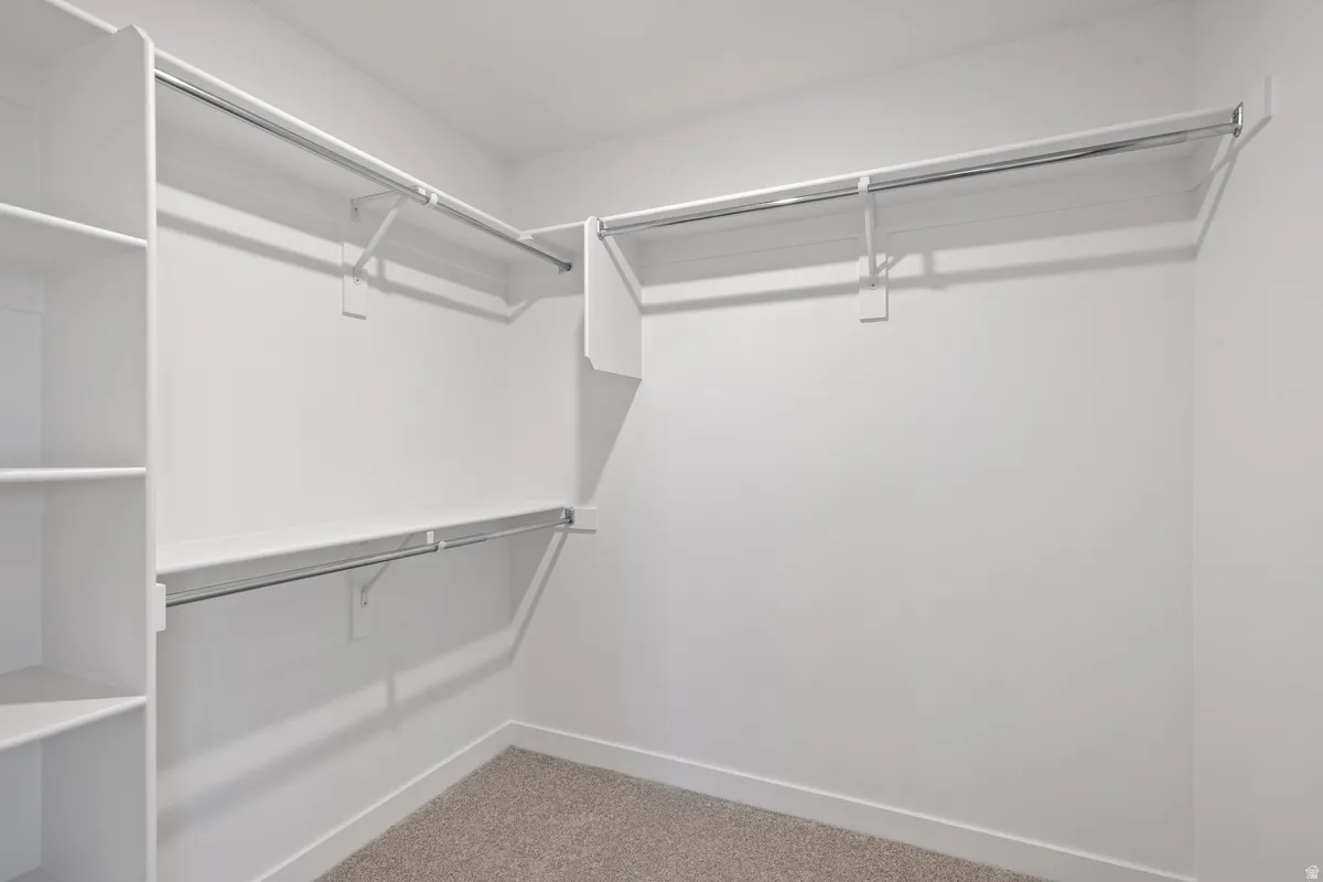 Custom shelving with integrated hanging rods, white finish, and light-toned carpeting