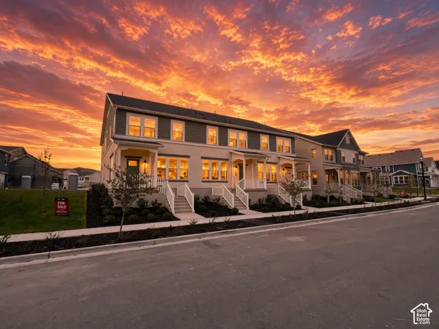 Row of townhomes featuring multi-pane windows, covered entryways, and white porch railings