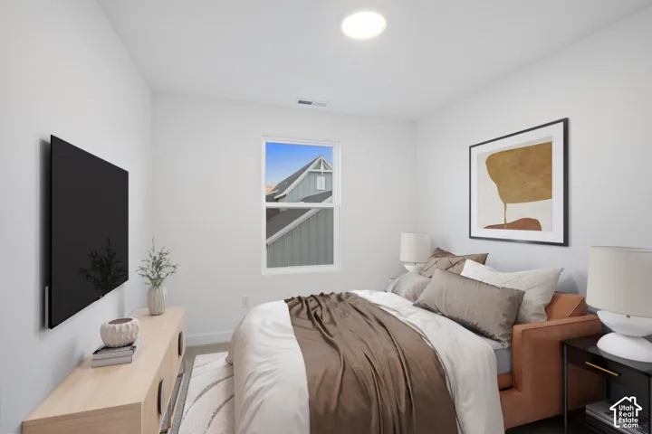 Recessed ceiling light, single window, light tone wall paint, neutral carpeting, and a built-in wall-mounted television