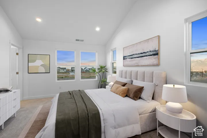 Vaulted ceiling, recessed lighting, multiple windows, wall-to-wall carpeting, and a substantial doorway