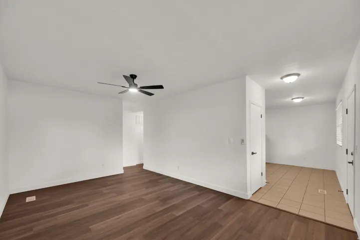 Wood-finish flooring, white walls, modern ceiling fan, recessed lighting, and tile flooring