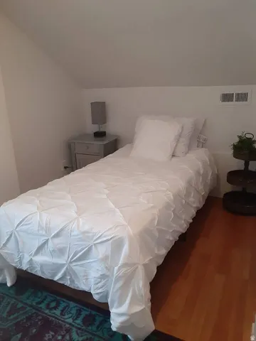 Wood-finish flooring with crisp white walls and sloped ceiling