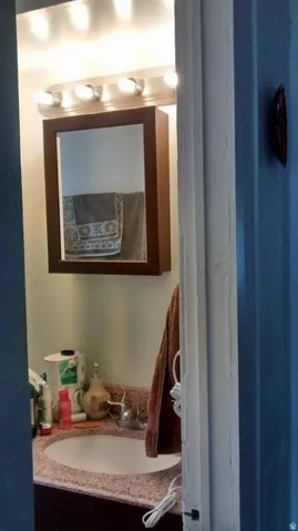 Vanity with an integrated sink, polished chrome faucet, and a framed medicine cabinet
