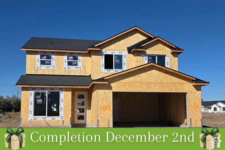 New construction framing with dual-pane windows, asphalt shingle roofing, and an integrated two-car garage