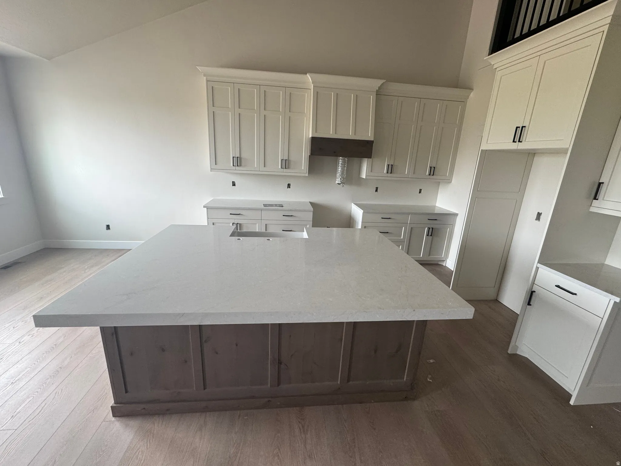 Kitchen island with a light-toned countertop and wood-finish base