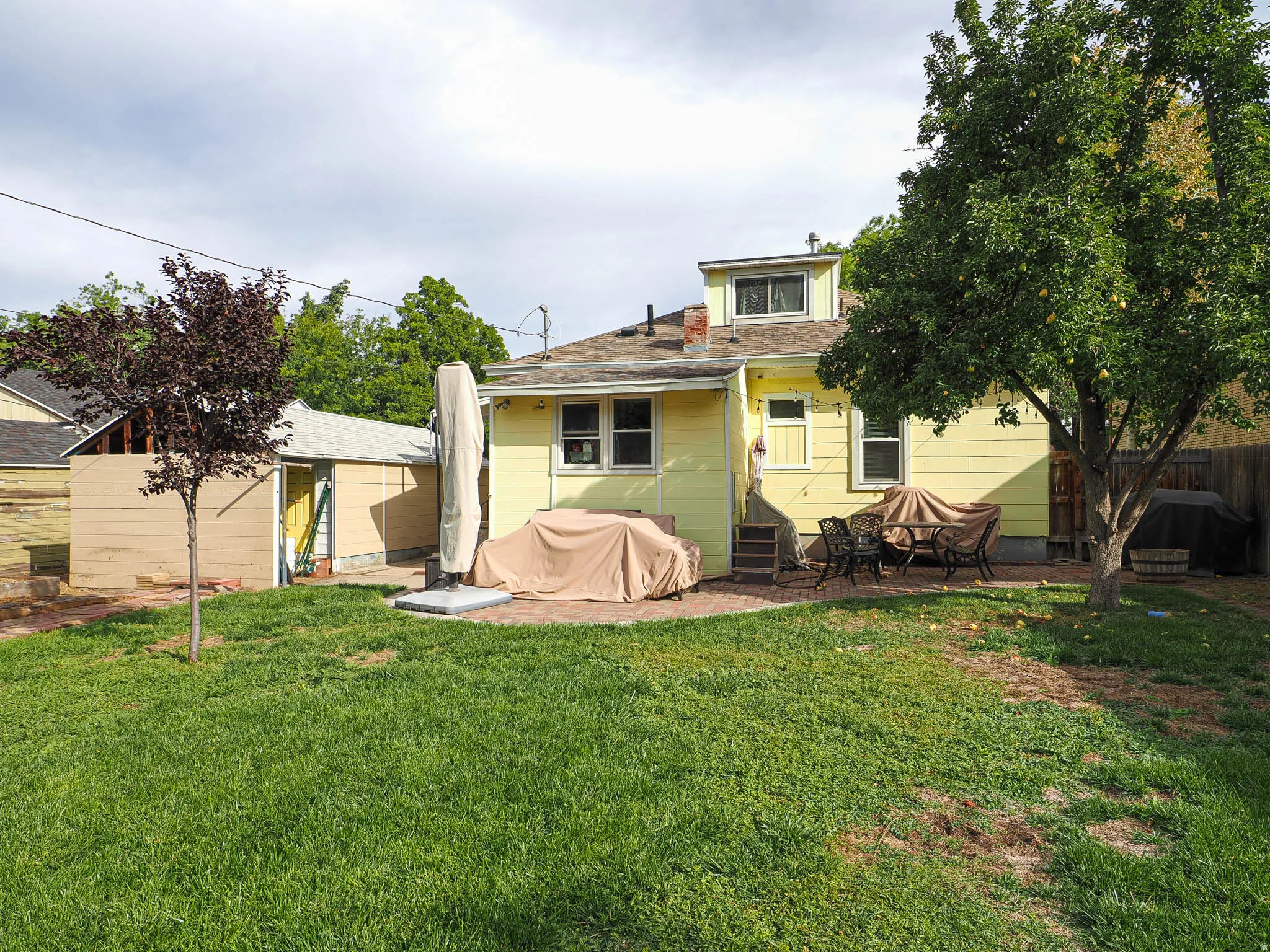 Expansive green lawn with mature trees and a dedicated patio area