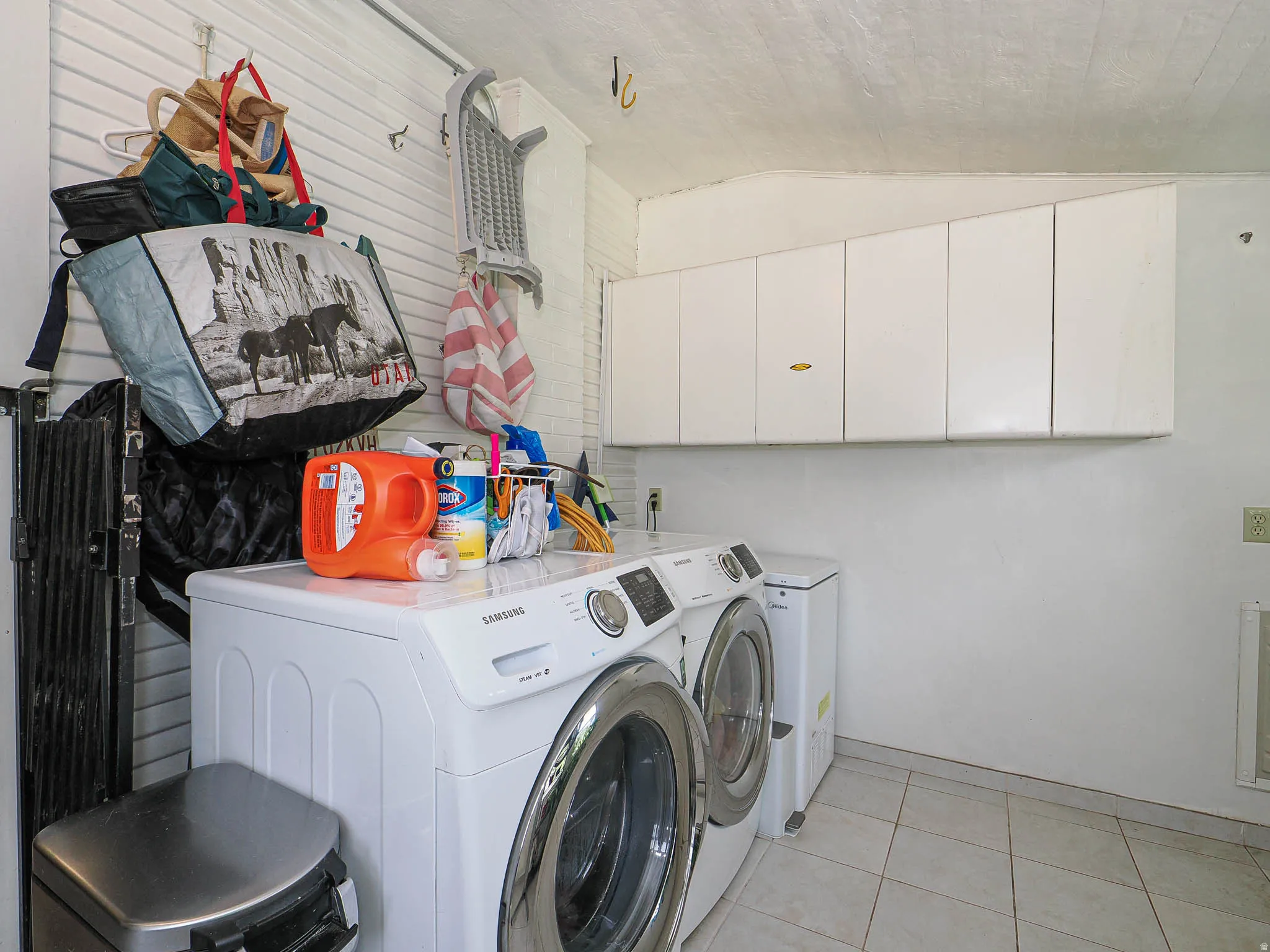 White cabinetry, tile flooring, and dedicated appliance space