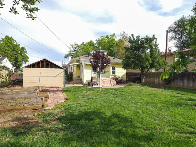 Expansive green lawn with a paver patio and mature trees