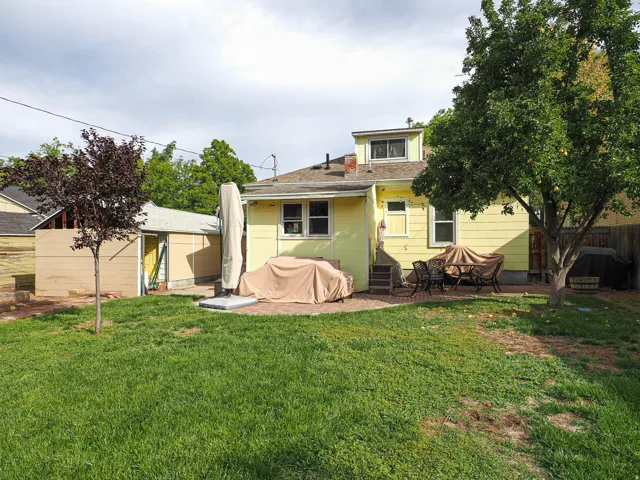 Expansive green lawn with mature trees and a dedicated patio area