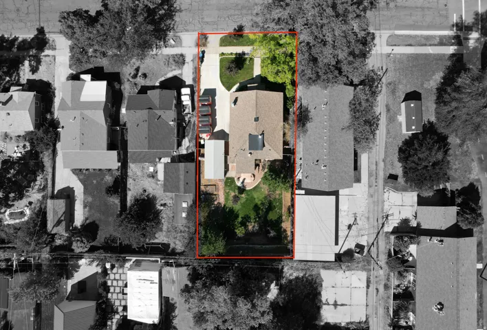 Expansive lot featuring a main residence, detached garage, and a large front yard