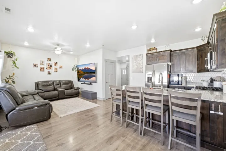Open-concept living area with Luxury vinyl wood-finish flooring, recessed lighting, and a ceiling fan