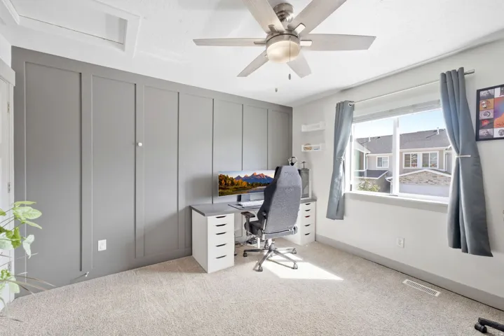 Textured wall paneling, ceiling fan with light fixture, large window, light-toned carpeting, and recessed lighting