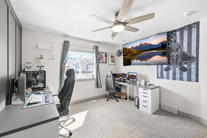 Recessed window, ceiling fan with integrated lighting, wall paneling, and carpet flooring