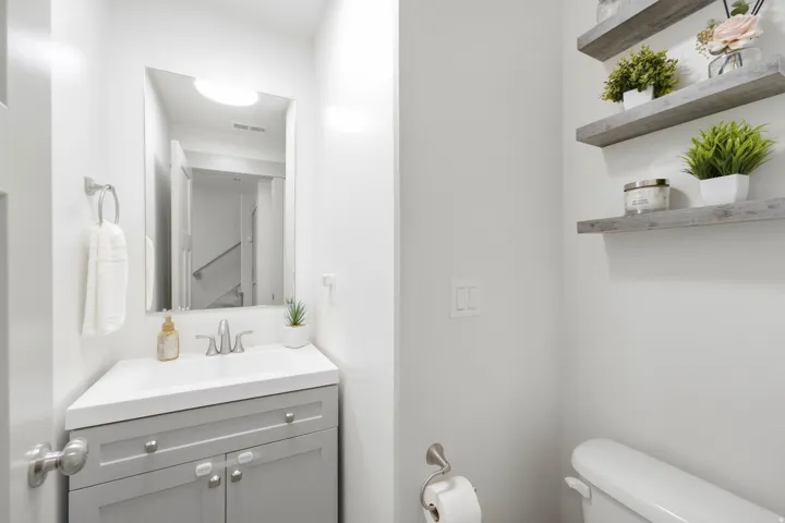 Corner vanity with an integrated basin, brushed nickel faucet, and coordinating hardware