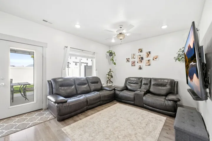 Spacious living area featuring wood-finish flooring, recessed lighting, and a ceiling fan