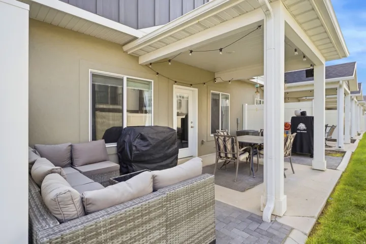 Covered patio with string lighting, direct yard access, and a durable hardscaping surface