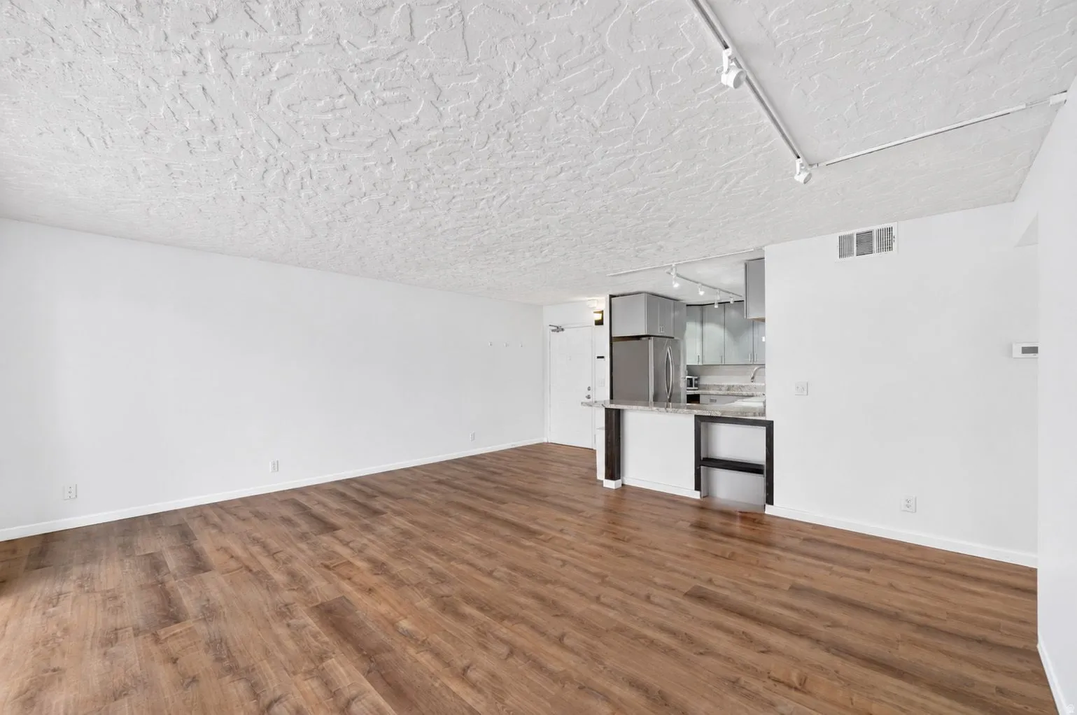 Open concept living area with wood-finish flooring