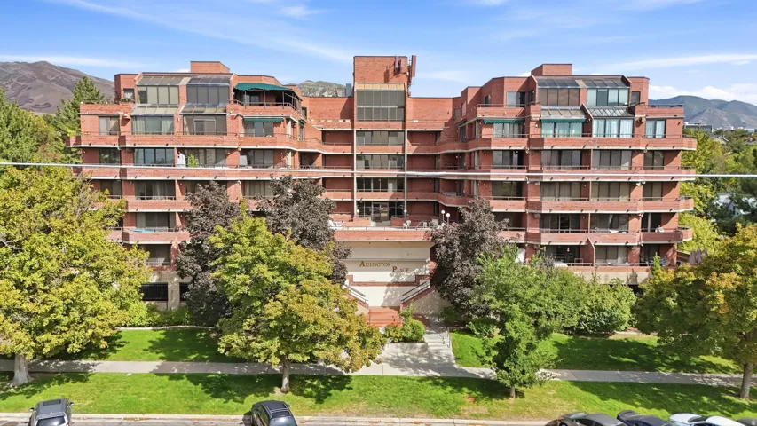 Red brick multi-story building featuring multiple balconies and sunrooms