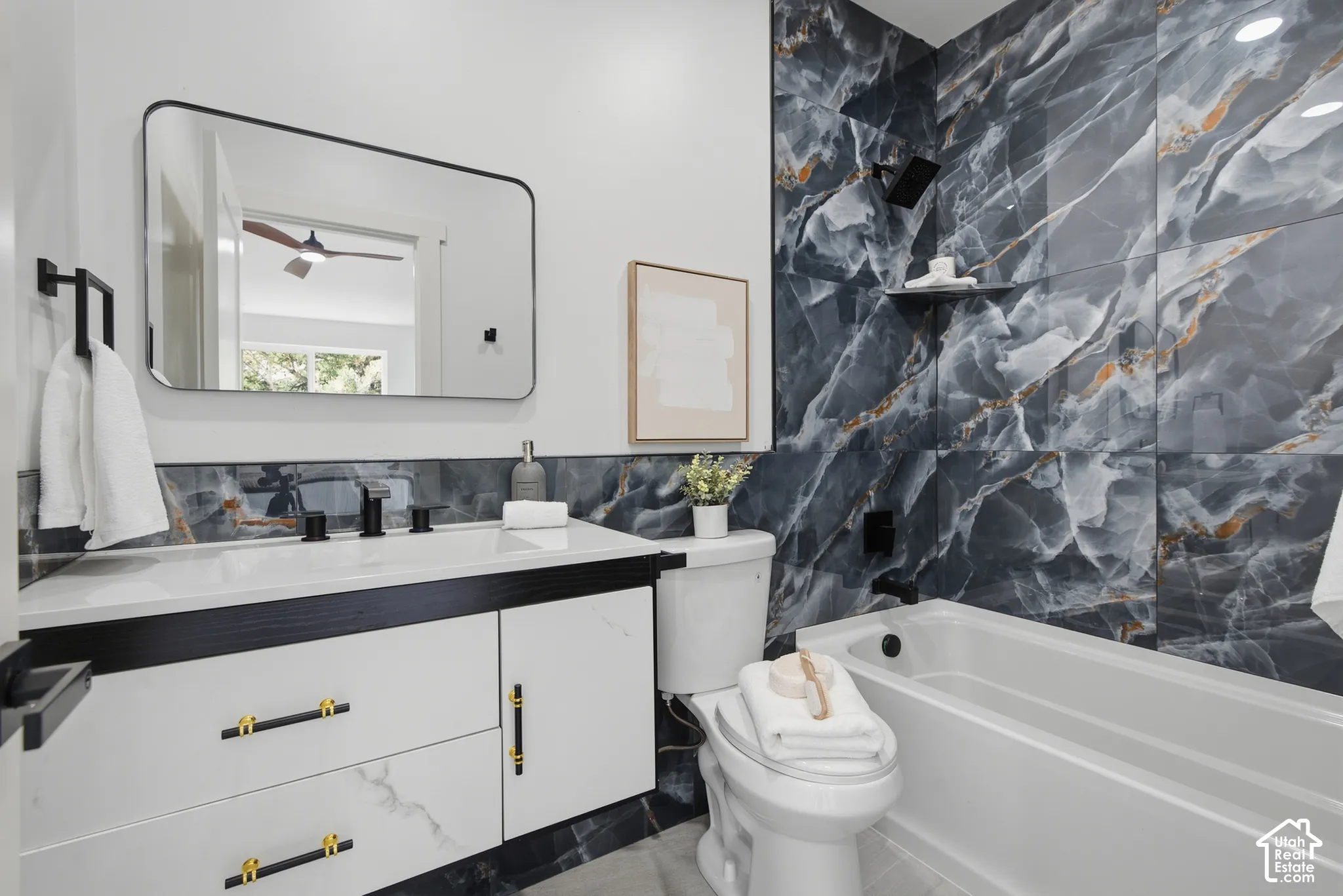 Floating vanity with gold-tone hardware and white countertop