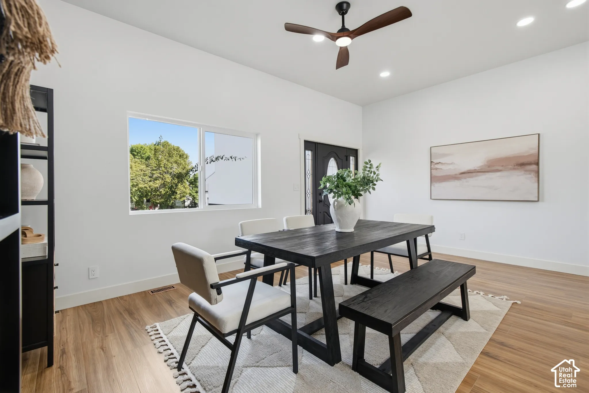 Recessed lighting, wood-finish flooring, white walls, and a ceiling fan with integrated lighting