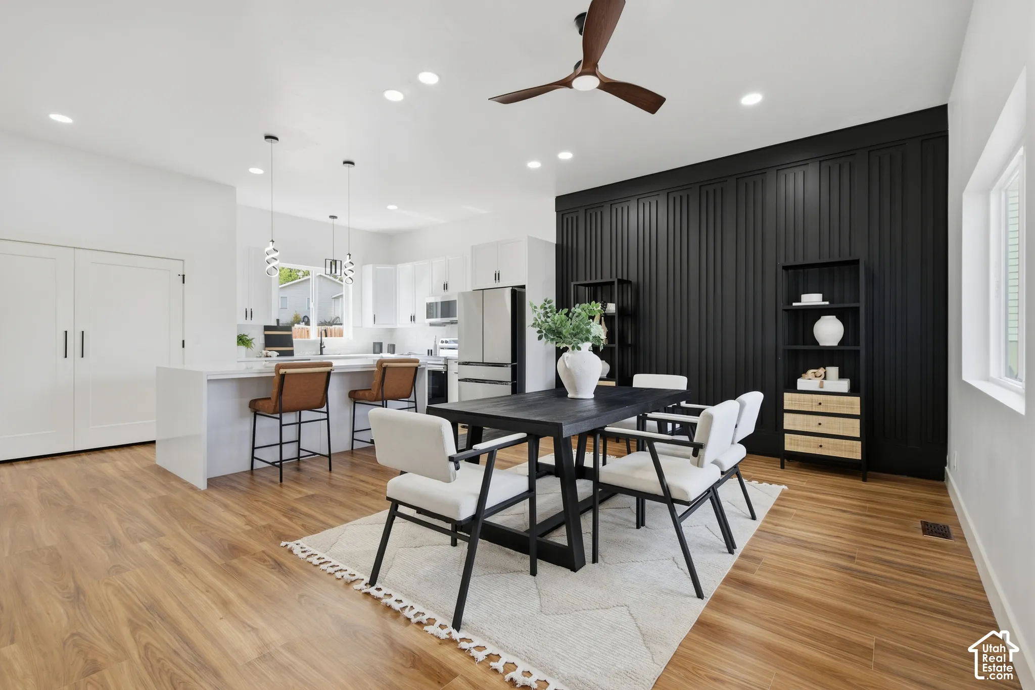 Wood-finish flooring throughout, recessed lighting, and a dark accent wall with vertical paneling