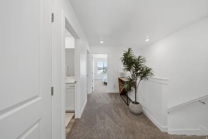 Carpeted hallway featuring recessed lighting and white panel doors