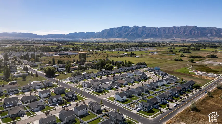 Residential development with a mountain backdrop, surrounded by undeveloped land and a road