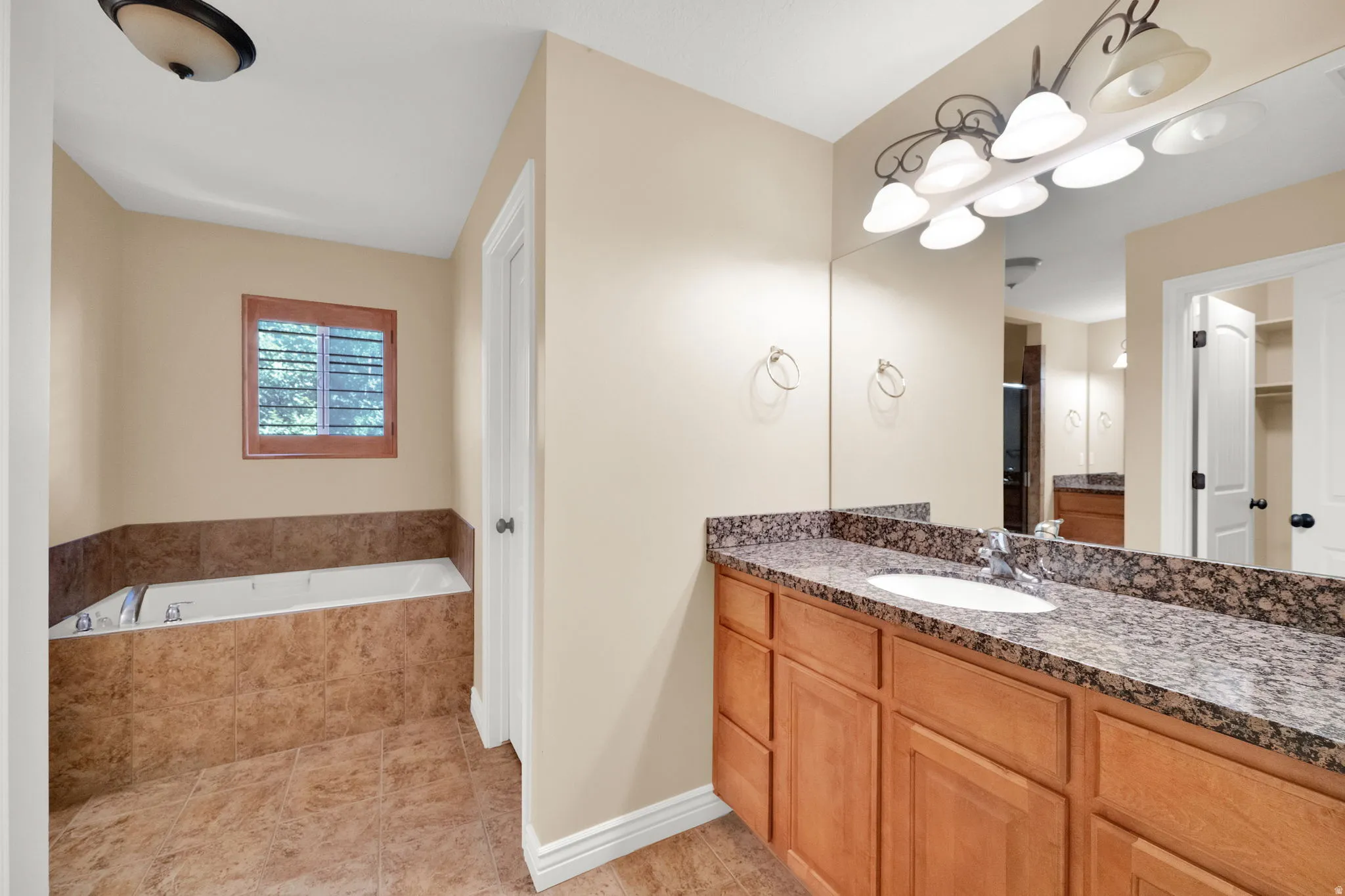 Dual vanity with an integrated sink, granite-style countertop, and wood-finish cabinetry