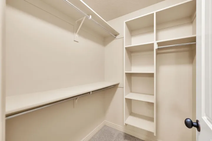 Built-in shelving, hanging rods, and an overhead shelf provide ample storage