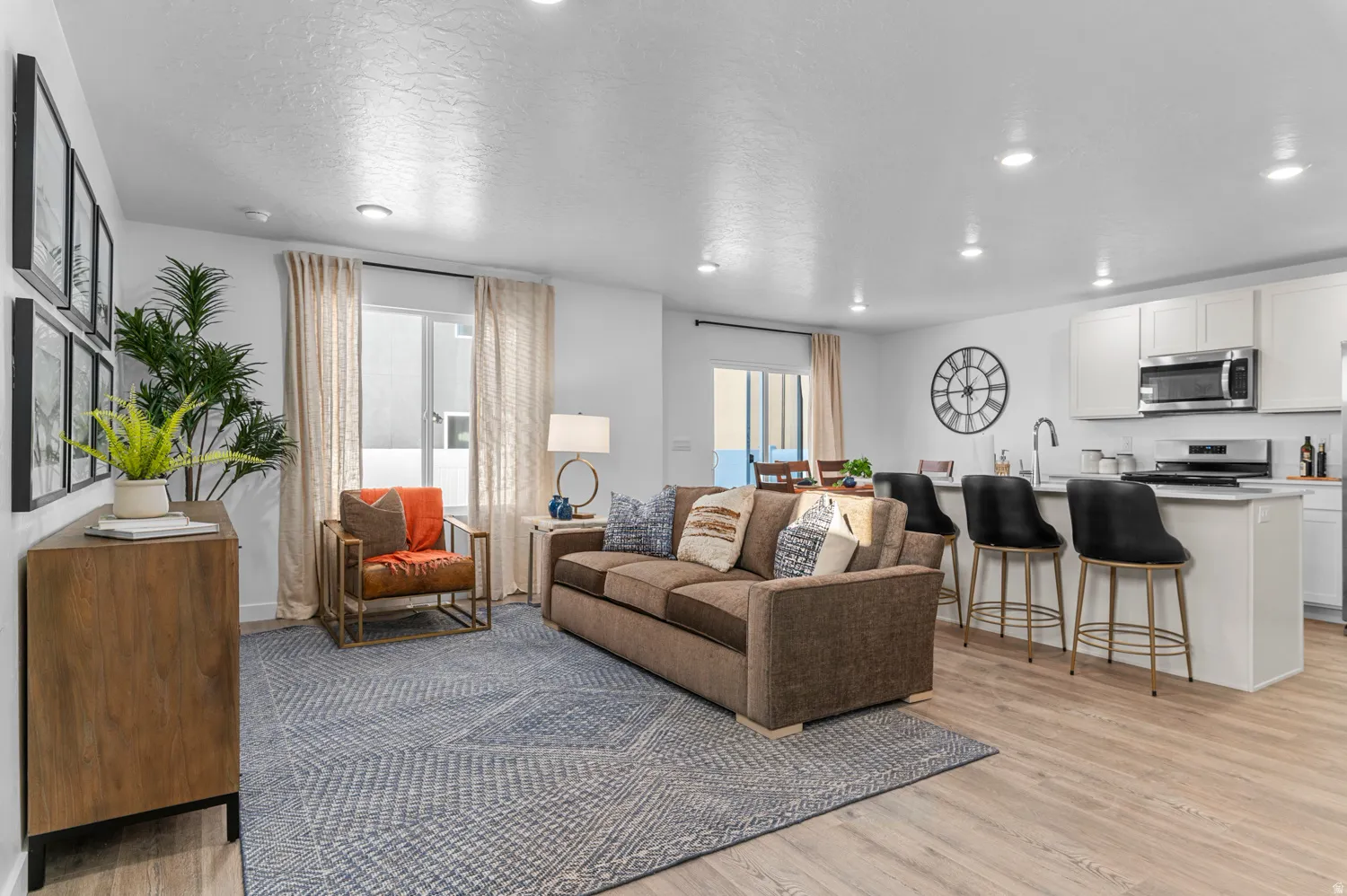 Open-concept living space featuring wood-finish flooring, recessed lighting, and white walls