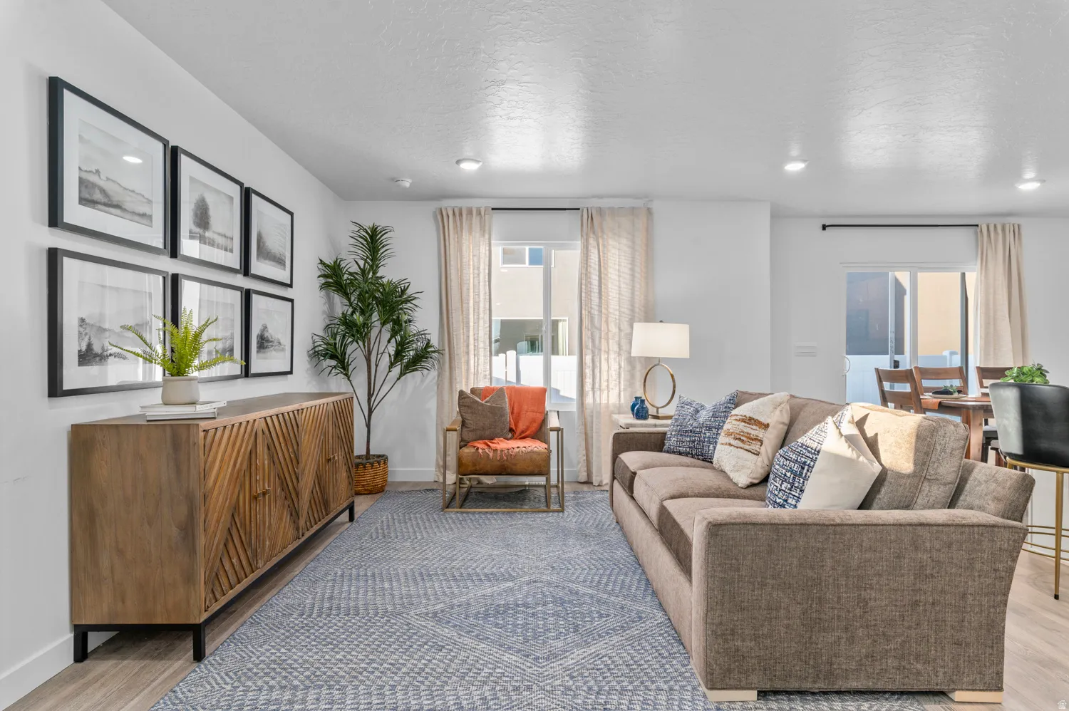 Recessed lighting, wood-finish flooring, white walls, and a sliding glass door