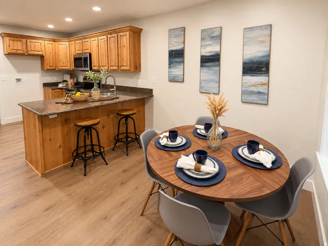 Wood-finish flooring throughout, featuring a kitchen with wood cabinetry and dark countertops