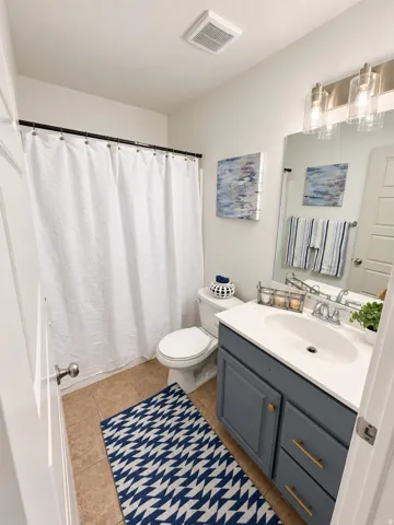 Vanity with a white countertop and oval sink, brushed nickel faucet, and a wall-mounted mirror