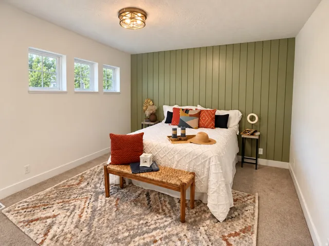 Recessed windows, accent wall with vertical paneling, ceiling-mounted light fixture, and neutral carpeting