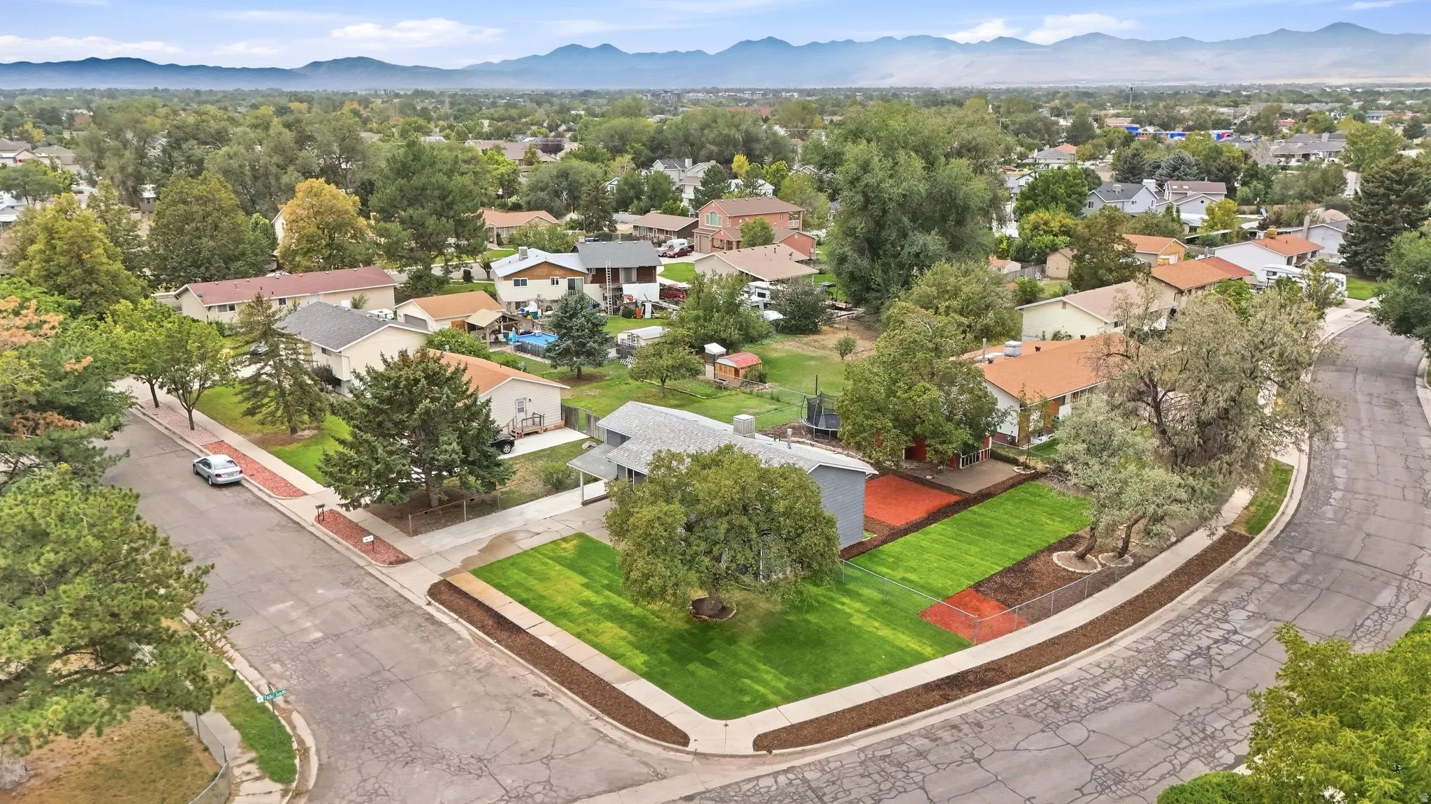 Corner lot with mature trees and a manicured lawn