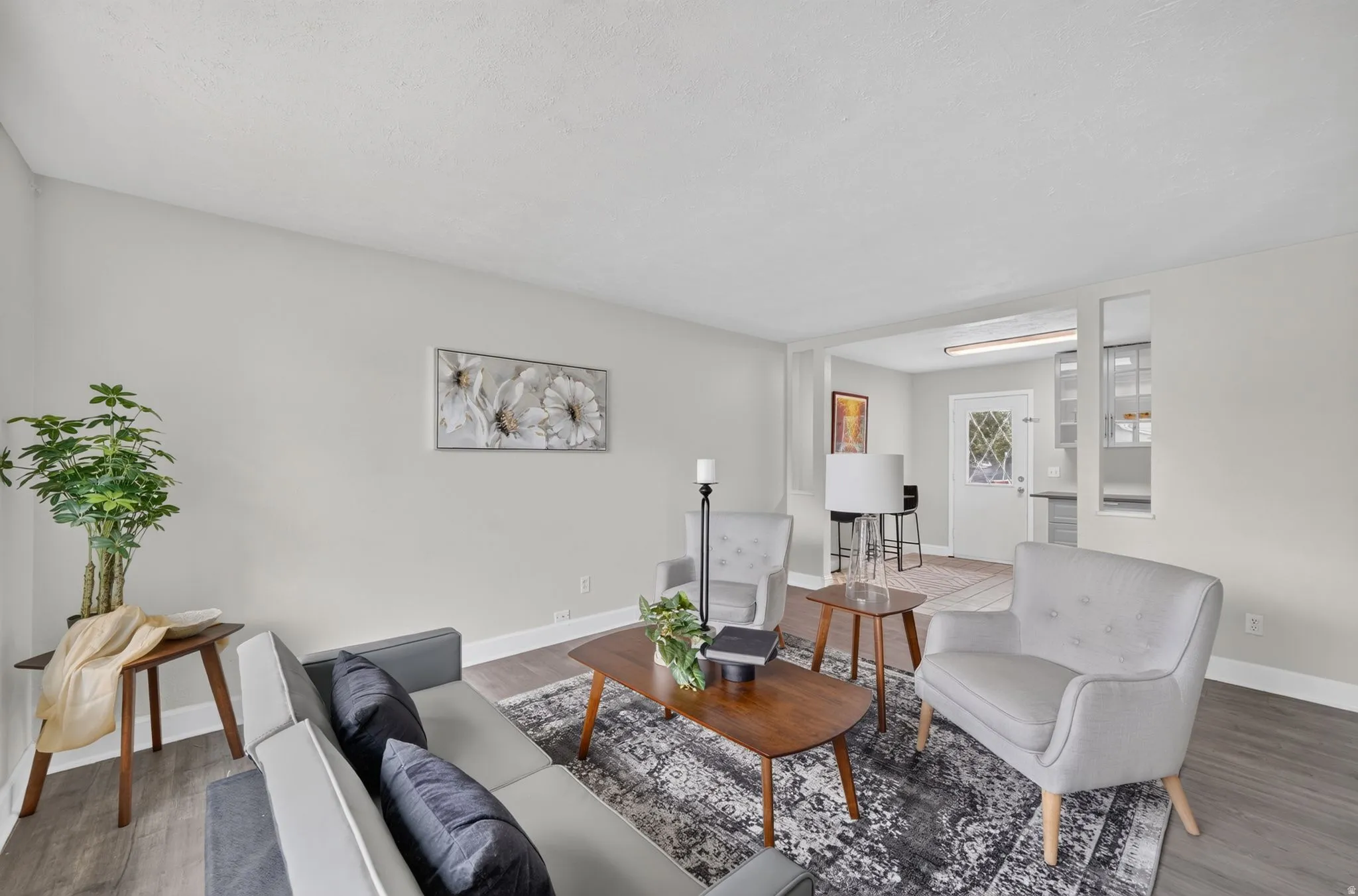 Recessed lighting, wood-finish flooring, light-toned walls, and a dedicated entry door with decorative glass