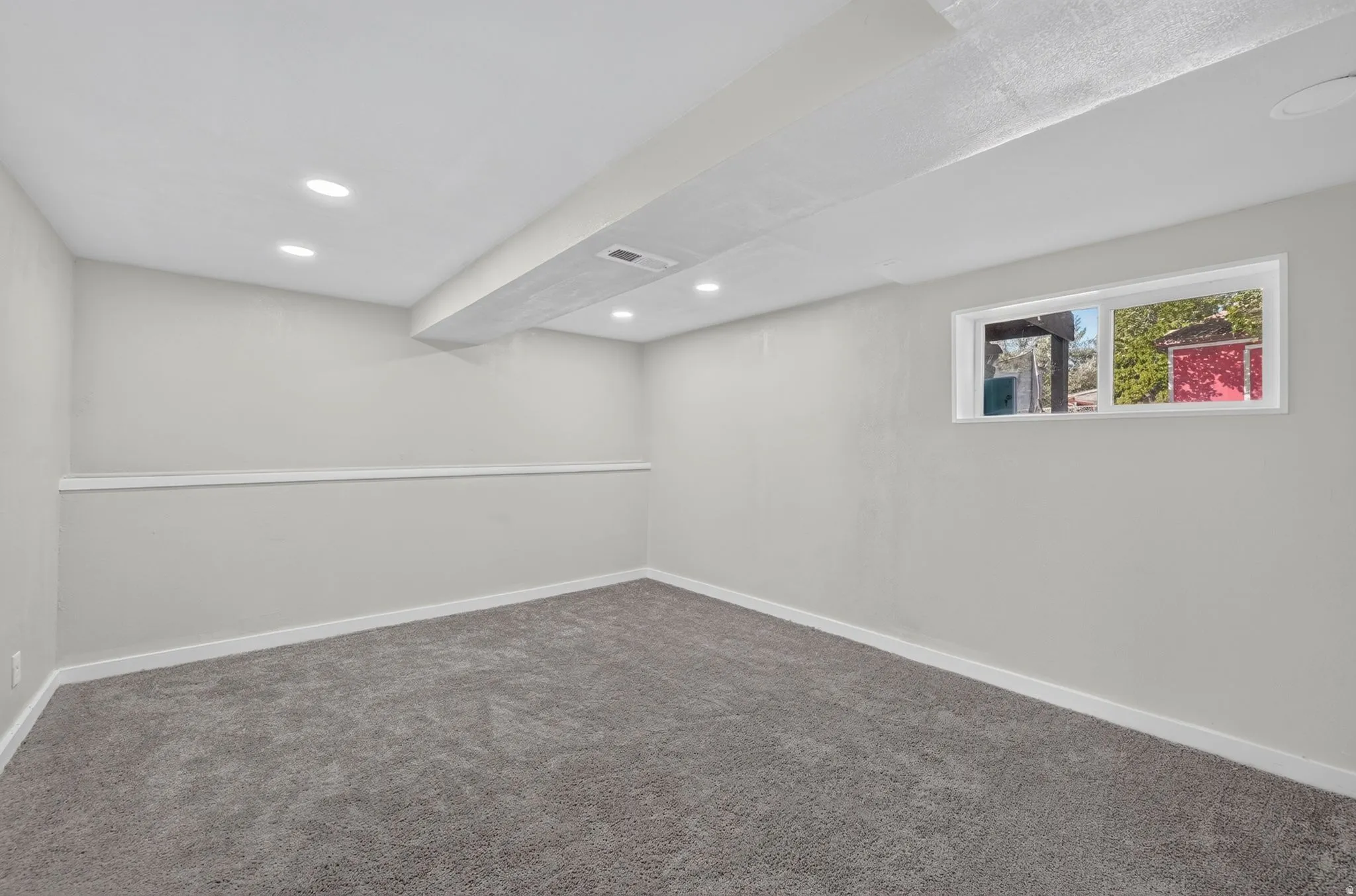 Recessed lighting illuminates the room, complemented by a single window