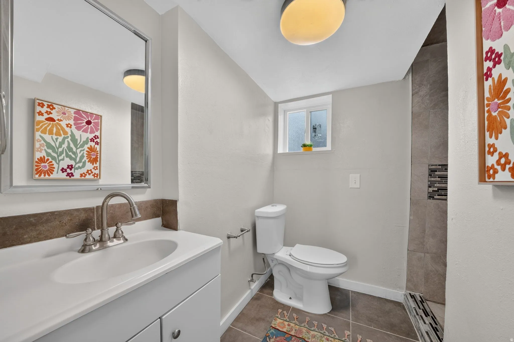 Vanity with integrated sink, brushed nickel faucet, and framed mirror