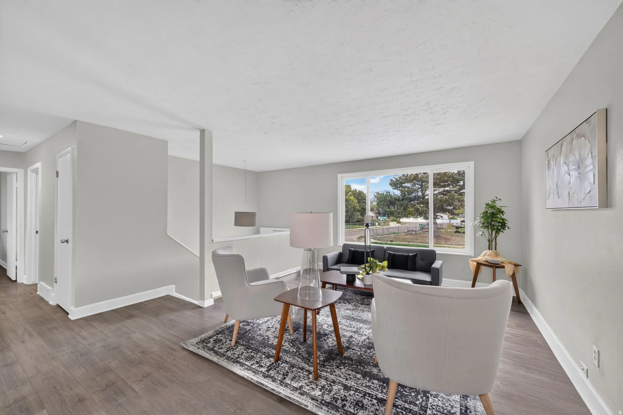 Light gray wall color, wood-finish flooring, white trim, and a prominent window
