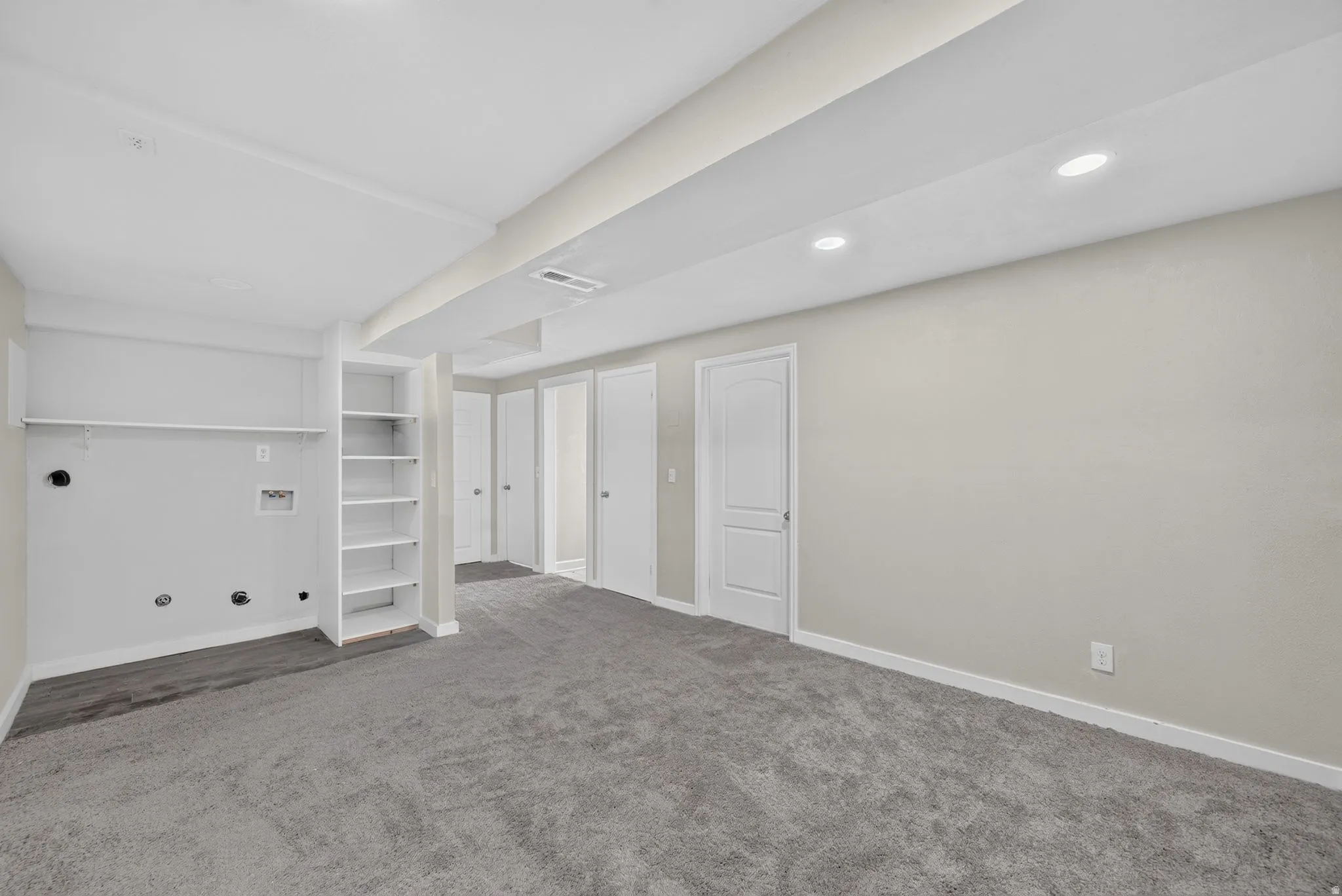 Spacious room featuring gray carpeting and light gray walls