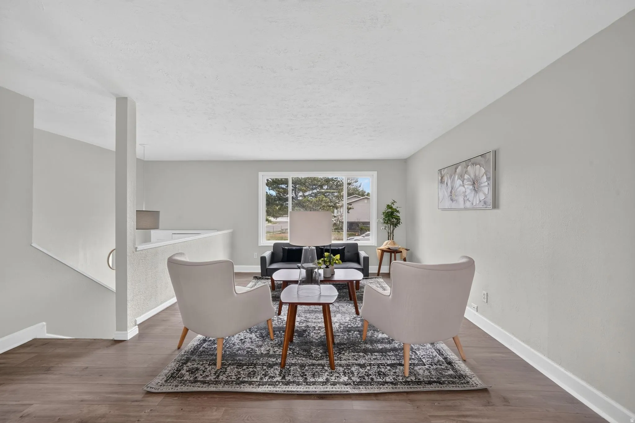 Wood-finish flooring throughout, light gray wall tones, and a prominent window