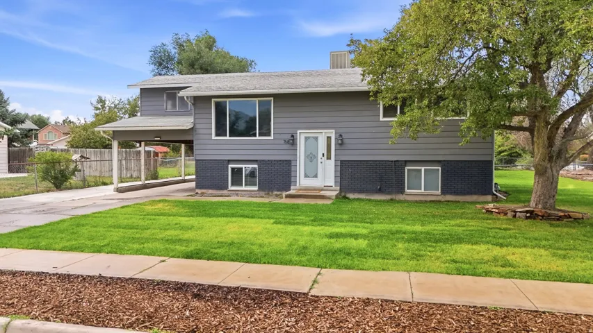 Split-level residence featuring gray siding and a contrasting brick facade