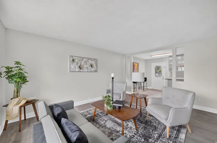 Recessed lighting, wood-finish flooring, light-toned walls, and a dedicated entry door with decorative glass