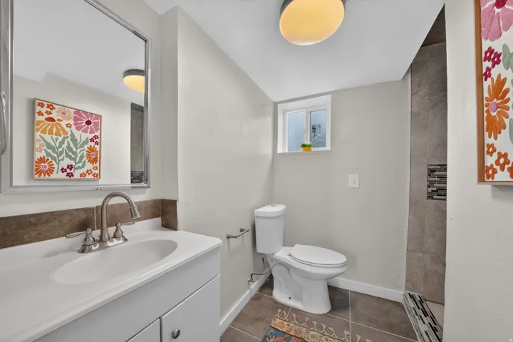 Vanity with integrated sink, brushed nickel faucet, and framed mirror