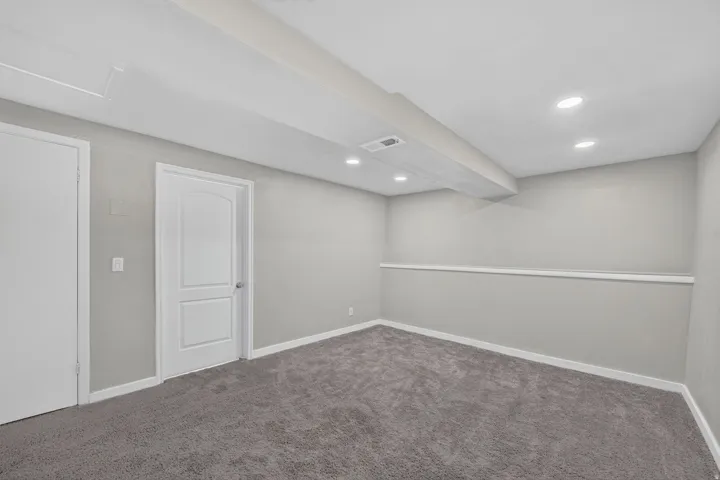 Recessed ceiling lighting, light gray wall paint, gray carpet flooring, white trim, and white paneled doors
